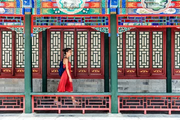 Fototapeten Junge Rucksacktouristin, die durch den alten traditionellen langen Korridor im chinesischen Tempel geht, Sommerreise in China. Asiatisches Mädchen, das Touristenattraktion in Peking besucht. © Maridav