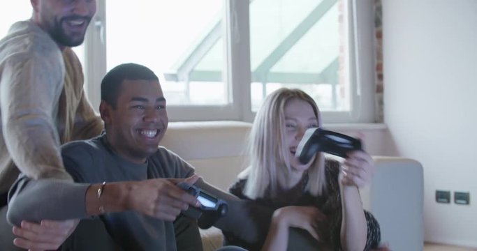 multiethnic group of friends people enjoy relaxing on couch playing videogames and having fun indoor in modern industrial house. 4k handheld video shot