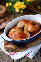 Chicken legs baked with fresh rosemary and pepper on an old wooden background. Rustic style.