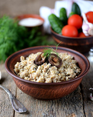 Buckwheat with chicken and mushrooms on an old wooden background. Rustic style.
