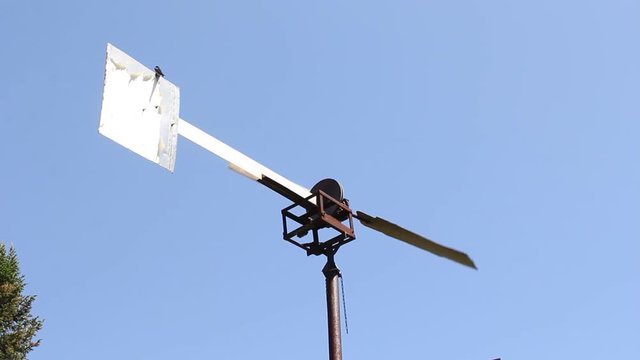 The windmill pumped water in Siberia against the blue sky.