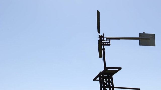 The windmill pumped water in Siberia against the blue sky.