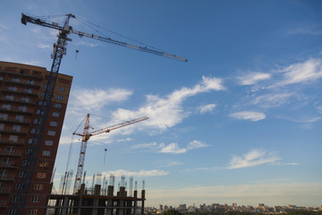 Construction site with cranes on sky background