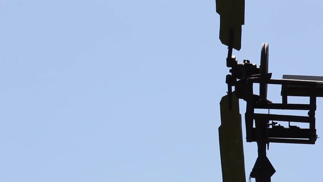 The windmill pumped water in Siberia against the blue sky.