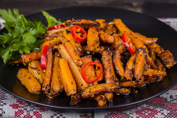 Roasted carrots in black plate, close up