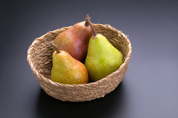 Ripe green and red pears on a black background
