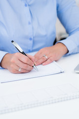 H&auml;nde einer Frau beim schreiben am Schreibtisch