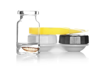 Glass bottle with brown lens, container and tweezers on white background