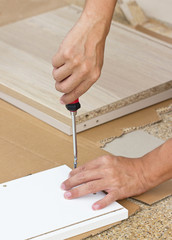 Asian Man's Hand Using Screw Driver Assembling Wooden Furniture