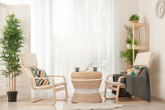 Beautiful modern veranda with cozy armchairs and coffee table