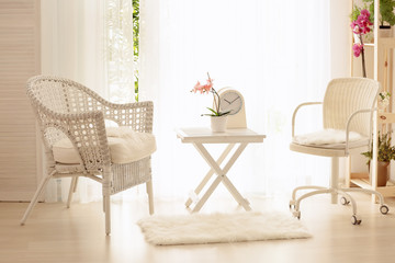 Beautiful modern veranda with cozy armchairs and coffee table