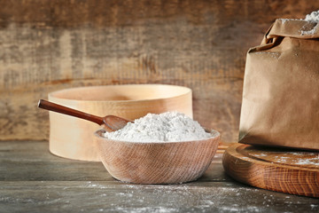 Bowl of flour on wooden background