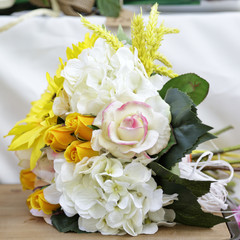 Bouquet of artificial flowers on a wooden table