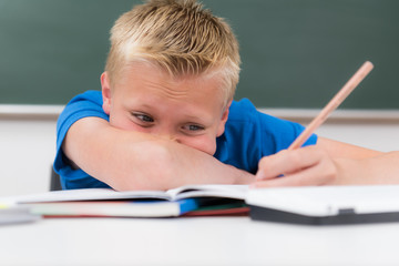verzweifelter schüler vor seinen aufgaben