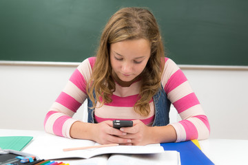 teenager spielt mit dem handy im unterricht