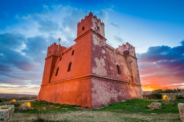 Il-Mellieha, Malta - The famous St Agatha's Tower or Red Tower at sunset with amazing colorful sky...