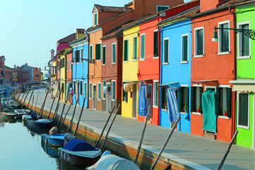 Fototapeta na wymiar Boats moored in the waterway near the colorful houses of the isl