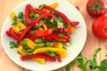 fresh vegetarian salad made with Bulgarian pepper and herbs. Wooden background. Top view. Close-up