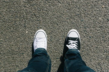 Black and white shoes on asphalt, personal perspective
