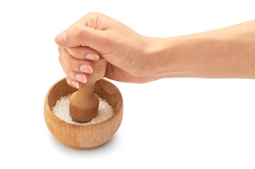 Female hand use wooden mortar with sea salt for cooking. Isolated on white background
