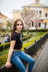 Young girl sitting on the city street in the Park.