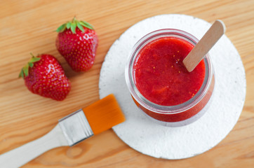 Homemade strawberry face mask in a glass jar. Diy cosmetics. Top view, close up, copy space.