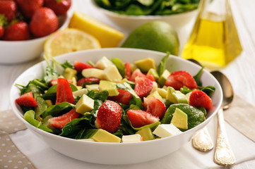 Spinach salad with strawberries, avocado and cheese.