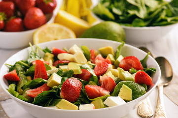 Spinach salad with strawberries, avocado and cheese.