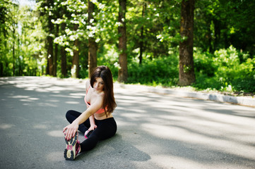 Fitness sport girl in sportswear sitting in road at park, outdoor sports, urban style.