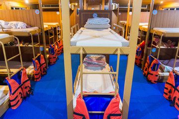 interior of a living cabin on a ship - with bunk beds and window.cabin with bunks for the crew on the old submarine.bunk beds on ferry boat to Koh Tao Island, Thailand