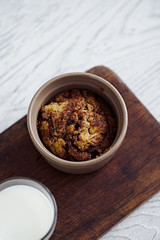 Baked muffin cake with cinnamon and brown sugar in a ceramic cake. White rustic wooden table