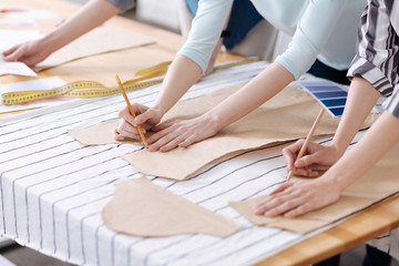Two pairs of female hands tracing patterns