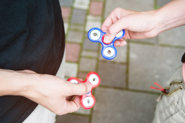 Close-up Two tweens spinners on the street against each other