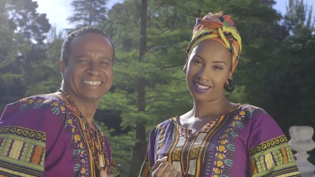 Father and adult daughter wearing traditional Brazilian clothing dancing together