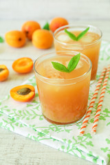 Apricot juice with ice cubes and apricots.