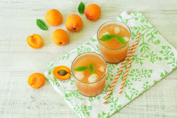 Apricot juice with ice cubes and apricots.