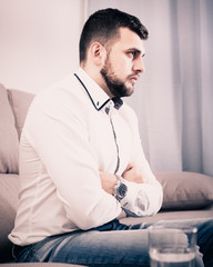 Man feeling distressed and lonely alone at home