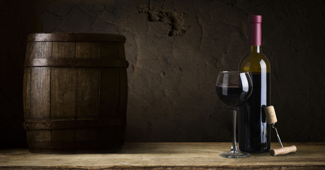 red wine bottle and wine glass on wodden barrel