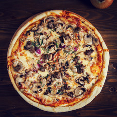 Delicious homemade pizza with mozzarella, mushrooms, beef and chicken.