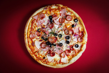 Delicious homemade pizza with mozzarella, ham, olives and fennel.