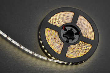 Reel of a diode strip with warm light on a stone dark background