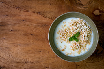 Natural yogurt with oat on wooden table ,top view