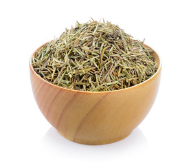 Dried rosemary leaves in wooden bowl over white background