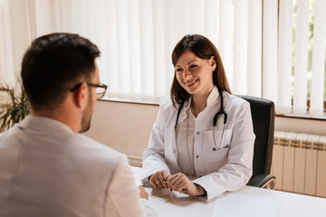Patient talking to young woman doctor in a hospital.