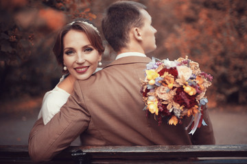 Newlyweds groom and bride walking in autumn park