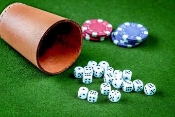 poker chips and dice on green background