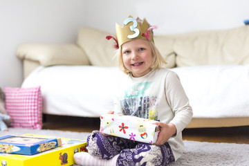 Fototapeta na wymiar Portrait kleines Mädchen mit Krone und Geschenken beim Geburtstag