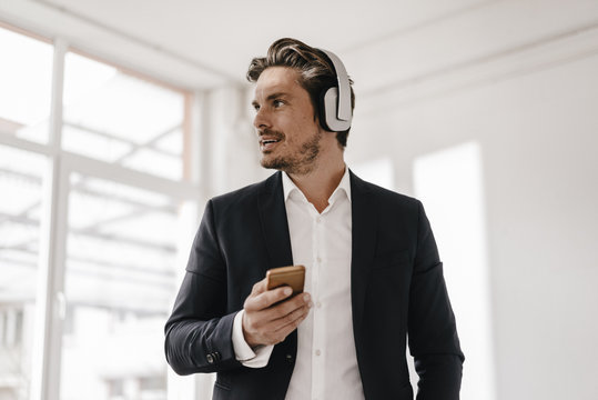 Businessman with cell phone and headphones