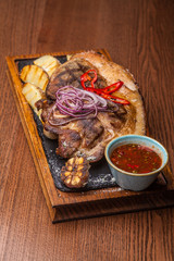 big fat fried steak on a wooden board with onions and fried potatoes with Bachall red wine, a nice feed at restaurant