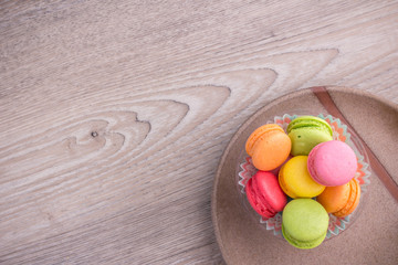 Sweet colorful macaroons on a wood background